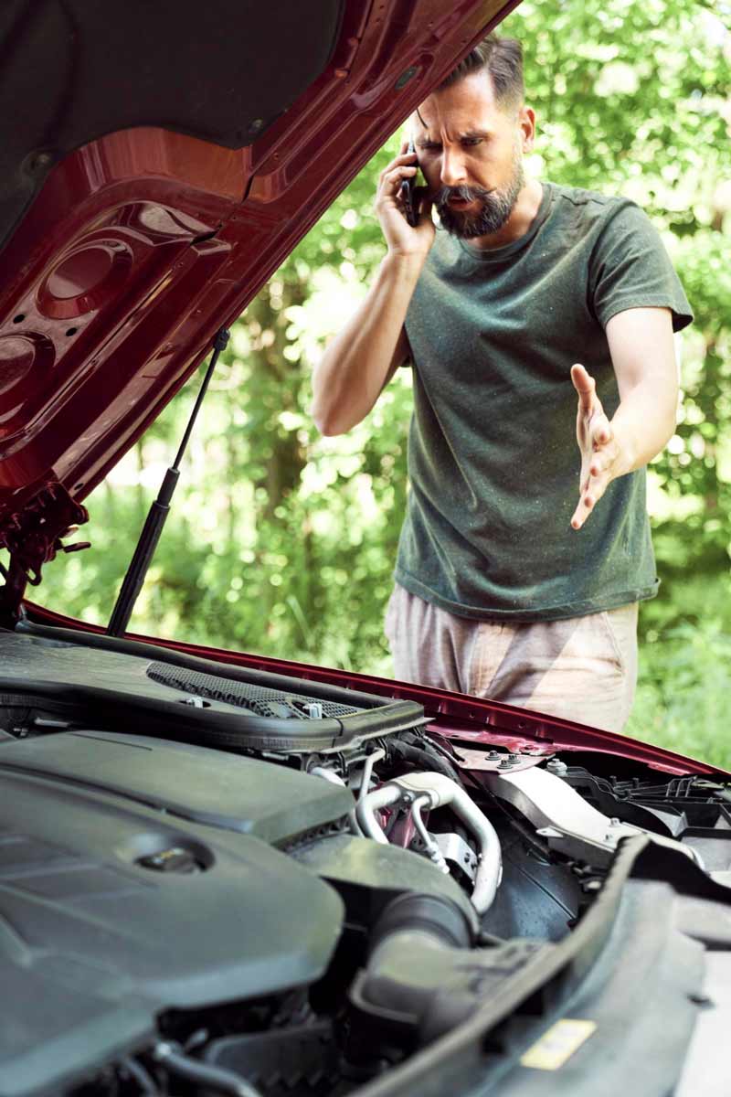 Junger Mann prüft Getriebeschaden bei Schrottauto Ankauf Eschborn